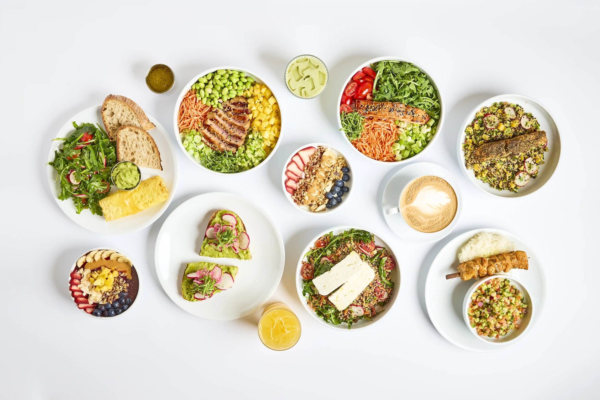 Selection of healthy bowls, salads, and beverages